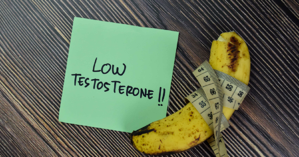 A green sticky note with the handwritten words _Low Testosterone!!_ placed next to a curved banana wrapped with a measuring tape, symbolizing male health issues in St. Louis, MO